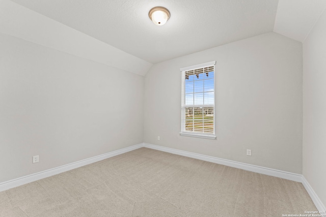 additional living space with carpet flooring, a textured ceiling, and vaulted ceiling