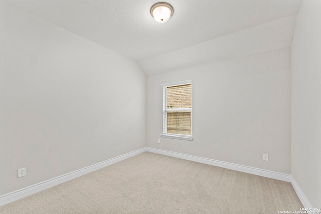 unfurnished room featuring carpet floors and lofted ceiling