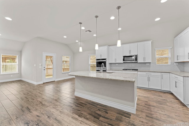 kitchen featuring appliances with stainless steel finishes, white cabinetry, and lofted ceiling