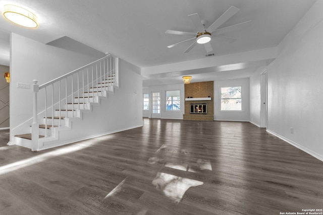 unfurnished living room featuring ceiling fan, dark hardwood / wood-style floors, and a fireplace