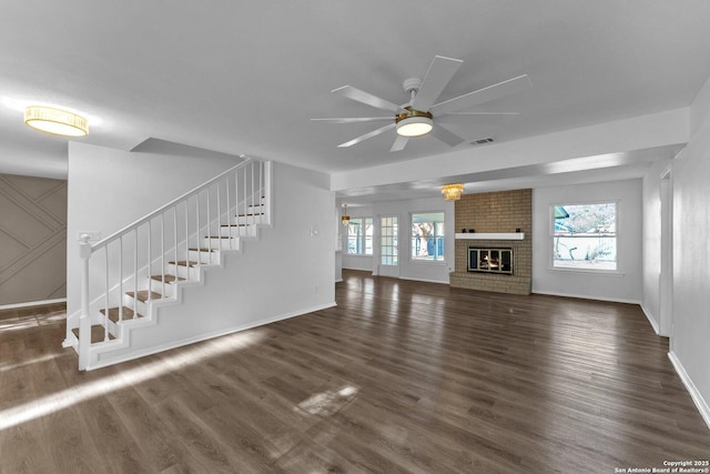 unfurnished living room featuring a fireplace, dark hardwood / wood-style flooring, and plenty of natural light