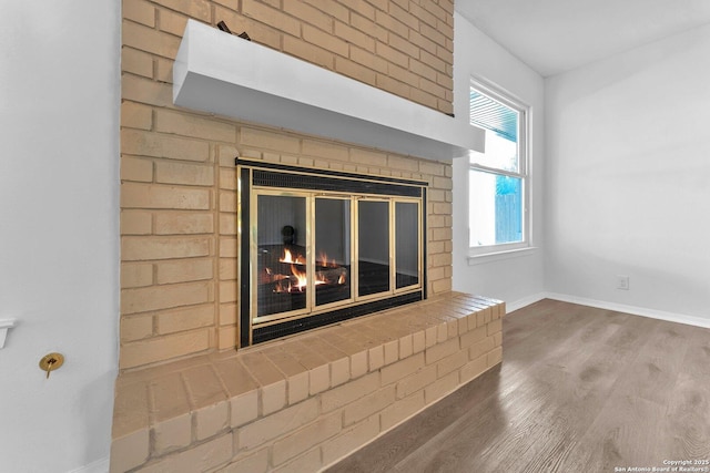 interior details featuring a fireplace and wood-type flooring