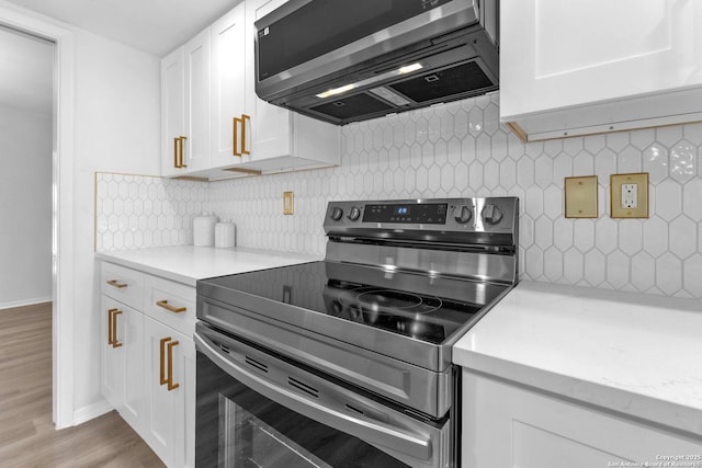 kitchen with light stone counters, light hardwood / wood-style flooring, backsplash, stainless steel electric range, and white cabinets