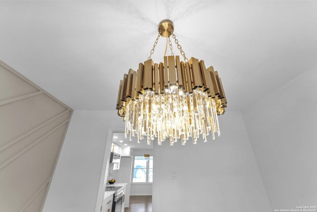 details featuring stainless steel range with electric stovetop and a notable chandelier