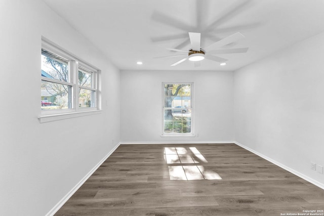 spare room with ceiling fan, dark hardwood / wood-style flooring, and a wealth of natural light