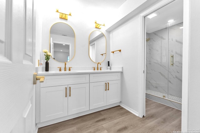 bathroom with hardwood / wood-style flooring, vanity, and walk in shower