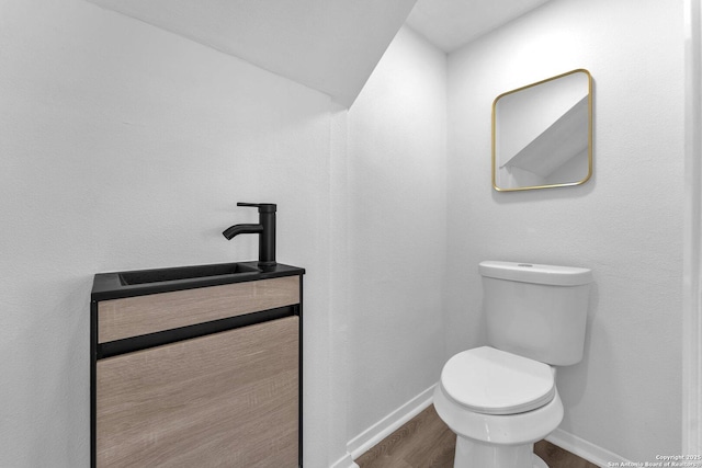 bathroom with hardwood / wood-style floors, vanity, and toilet