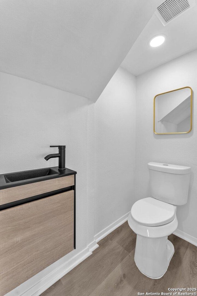 bathroom featuring hardwood / wood-style floors, vanity, and toilet