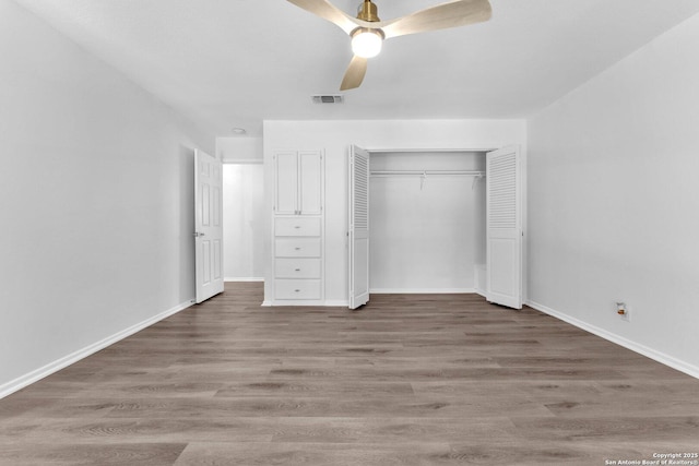 unfurnished bedroom with a closet, hardwood / wood-style flooring, and ceiling fan