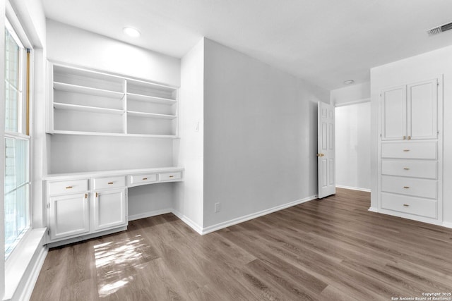 interior space with built in desk and dark wood-type flooring