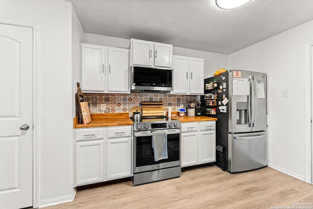 kitchen with decorative backsplash, white cabinetry, appliances with stainless steel finishes, and light hardwood / wood-style flooring