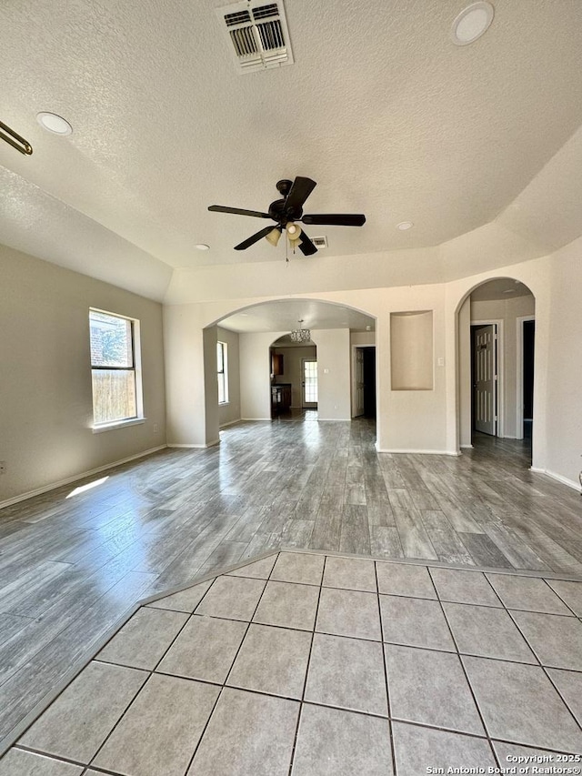 unfurnished living room with ceiling fan, light hardwood / wood-style floors, and a textured ceiling