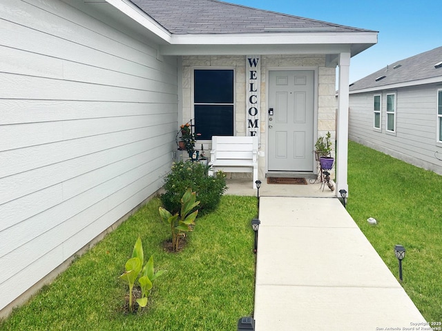 view of exterior entry with a lawn