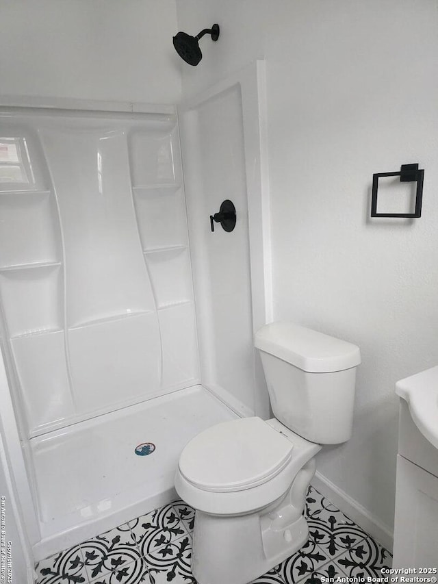 bathroom featuring a shower, tile patterned flooring, vanity, and toilet