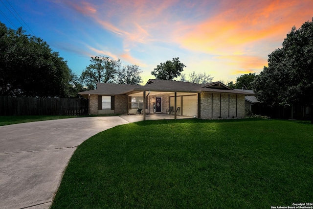 ranch-style house featuring a yard and a garage