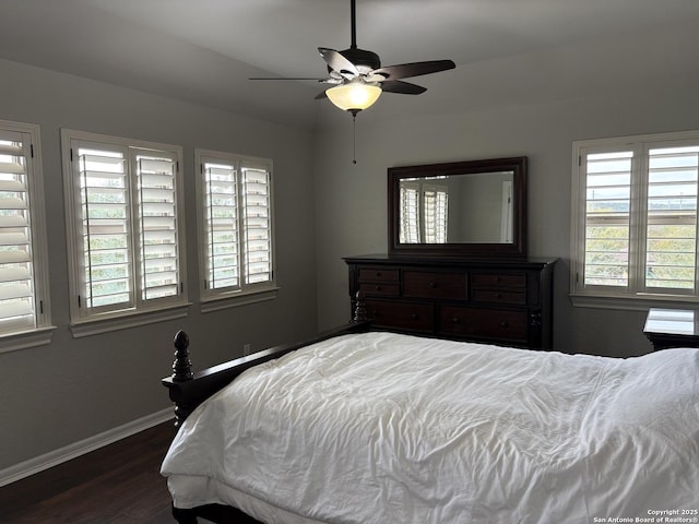 bedroom featuring multiple windows, ceiling fan, and dark hardwood / wood-style floors