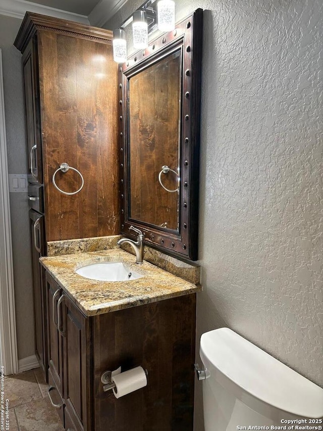 bathroom featuring vanity, toilet, and ornamental molding