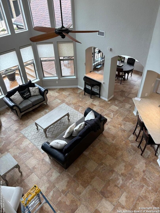 living room featuring a high ceiling and ceiling fan