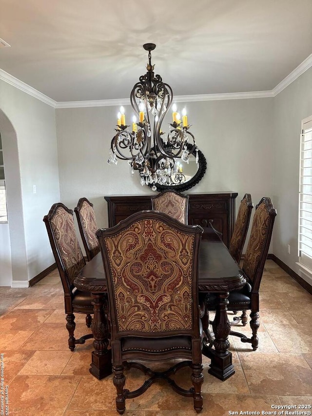 dining space featuring crown molding and a chandelier