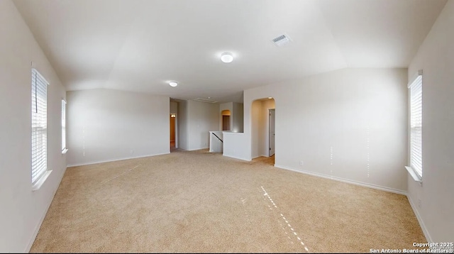 unfurnished room with light carpet and vaulted ceiling