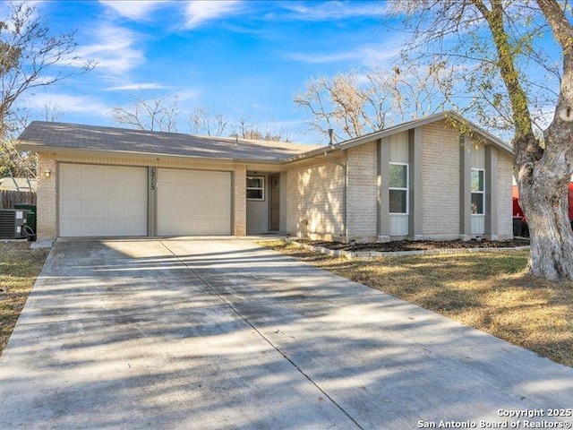 ranch-style home with a garage and central air condition unit