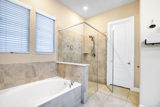 bathroom with tile patterned floors and shower with separate bathtub