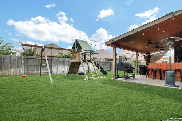 view of yard with a playground, a patio area, ceiling fan, and an outdoor bar