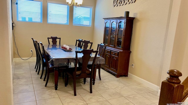 tiled dining room with an inviting chandelier