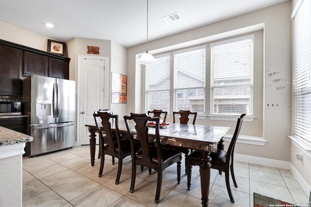 tiled dining area featuring a healthy amount of sunlight