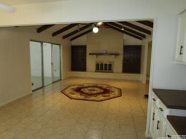 living room featuring light tile patterned floors, vaulted ceiling with beams, a brick fireplace, and ceiling fan