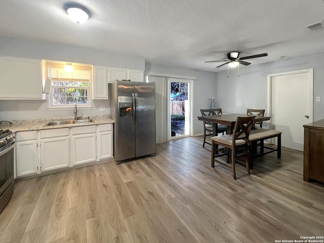 kitchen with white cabinets, appliances with stainless steel finishes, light hardwood / wood-style flooring, and sink