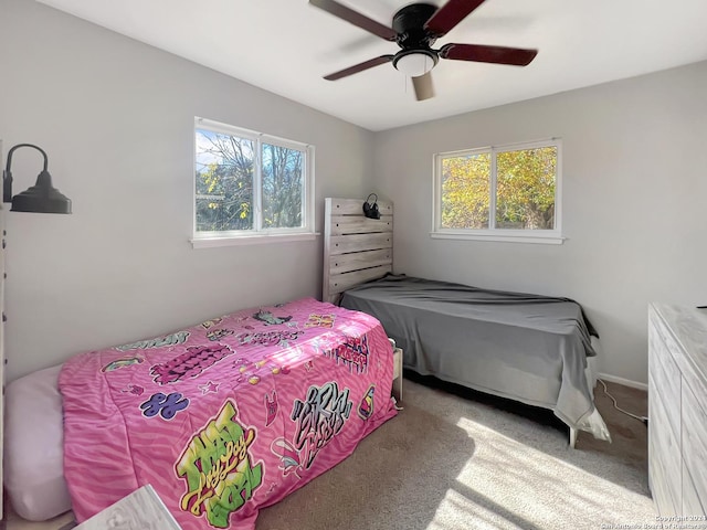 carpeted bedroom featuring multiple windows and ceiling fan