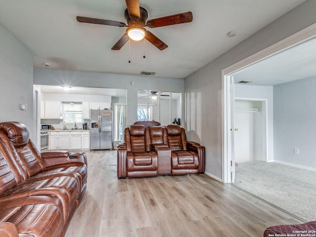 living room with ceiling fan and light hardwood / wood-style floors