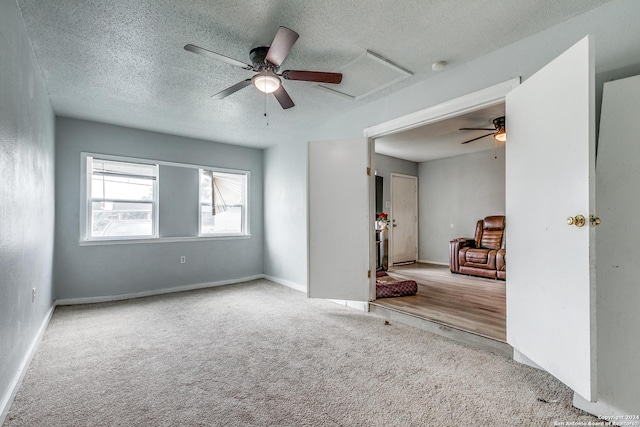 carpeted empty room featuring ceiling fan and a textured ceiling