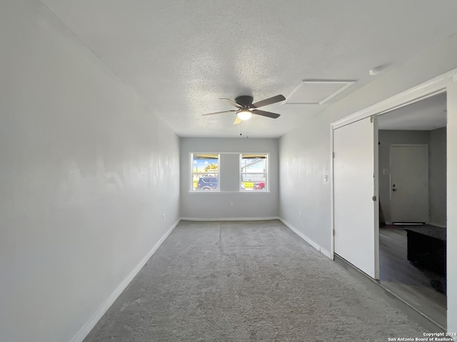 spare room featuring carpet flooring, ceiling fan, and a textured ceiling