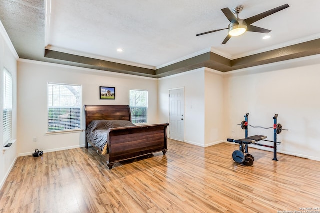 bedroom featuring ceiling fan, crown molding, and a tray ceiling