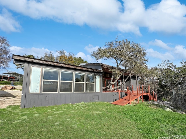 back of property featuring a lawn