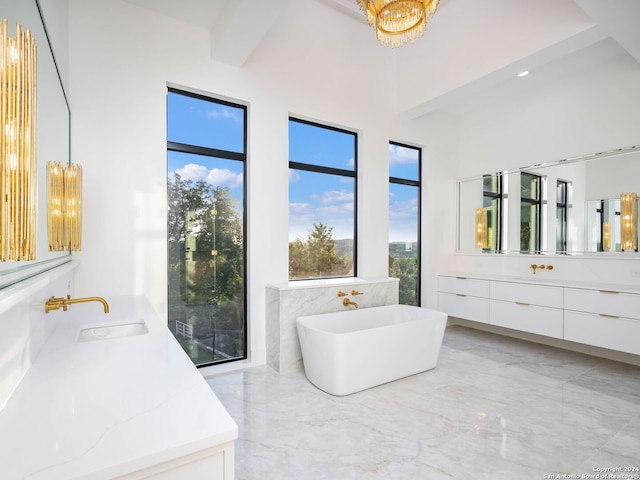 bathroom with vanity, a washtub, and an inviting chandelier