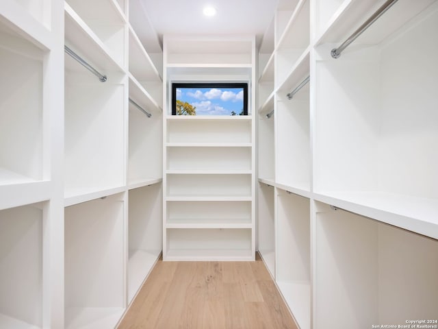 walk in closet with light hardwood / wood-style floors