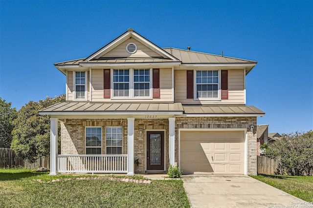 view of front of house featuring a front lawn, covered porch, and a garage