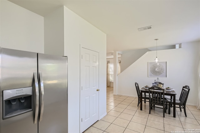 kitchen with stainless steel fridge, light tile patterned flooring, and hanging light fixtures