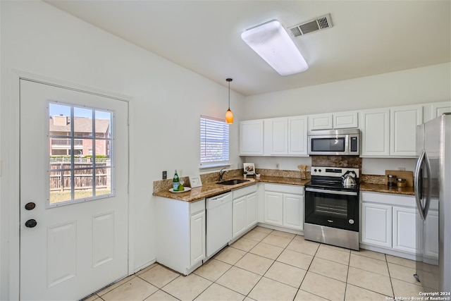 kitchen with sink, stainless steel appliances, light tile patterned floors, decorative light fixtures, and white cabinets