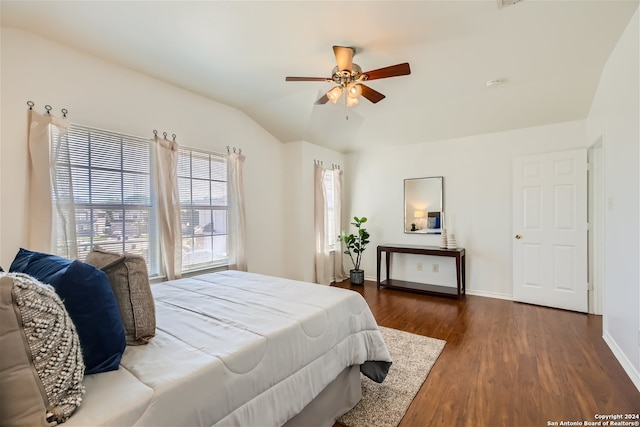 bedroom with ceiling fan, dark wood-type flooring, and vaulted ceiling