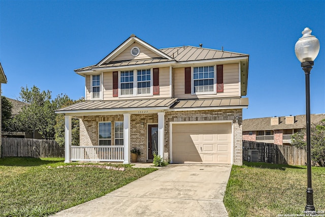 view of front of house featuring a porch, a front yard, and a garage