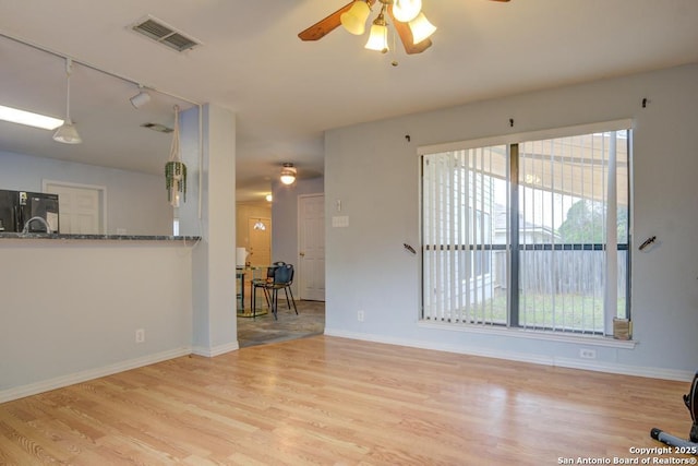 living room featuring a wealth of natural light, ceiling fan, and light hardwood / wood-style floors