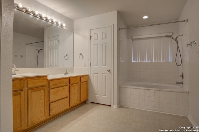 bathroom featuring vanity and tiled shower / bath