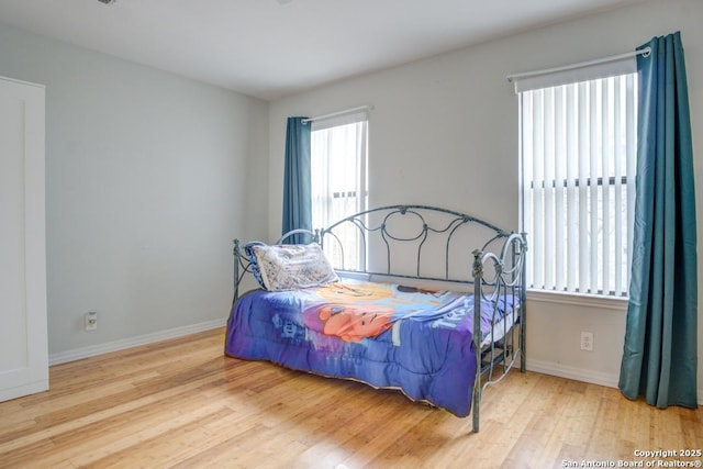 bedroom featuring multiple windows and wood-type flooring