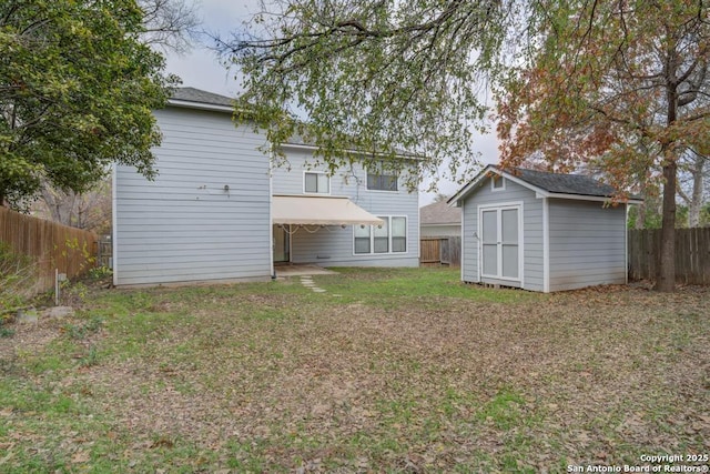 rear view of property featuring a storage unit