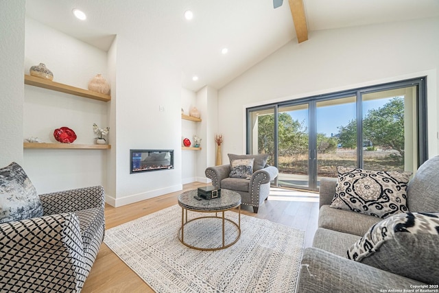 living room with light hardwood / wood-style flooring and lofted ceiling with beams