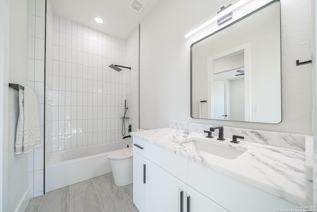 full bathroom featuring vanity, toilet, and tiled shower / bath combo